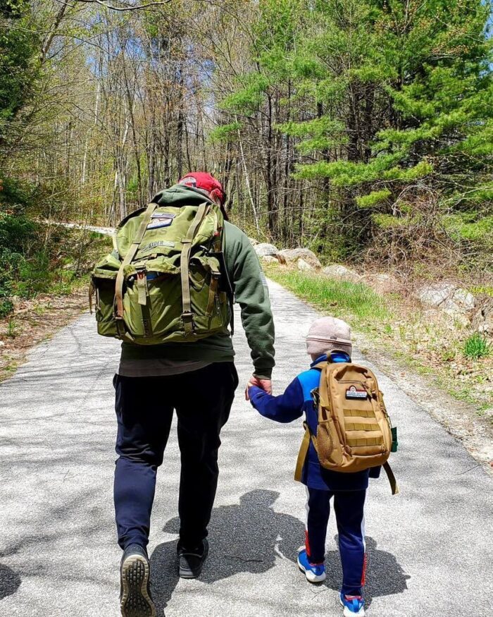 Father and son holding hands while ruck marching